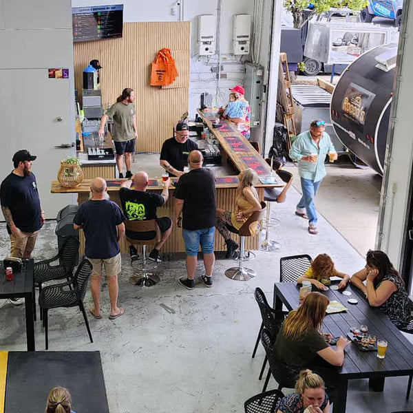 A lively scene at a craft beer breweries in Brisbane, featuring patrons enjoying local brews and a vibrant atmosphere.