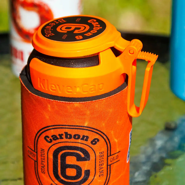 C6 Klever Cap beer can flip lid in use, showcasing a hand holding a can with a bright orange cap.