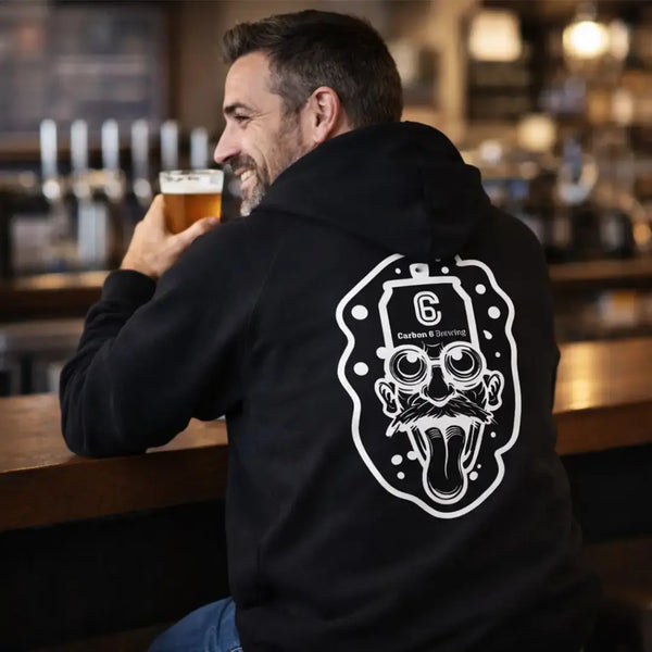 Man wearing Carbon 6 Can Head Brewer Fleece Hoodie, showcasing unique design while enjoying a beer.