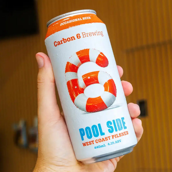 The Occasional Beer by Carbon 6 Brewing, Pool Side West Coast Pilsner in a hand, 440ml can design.