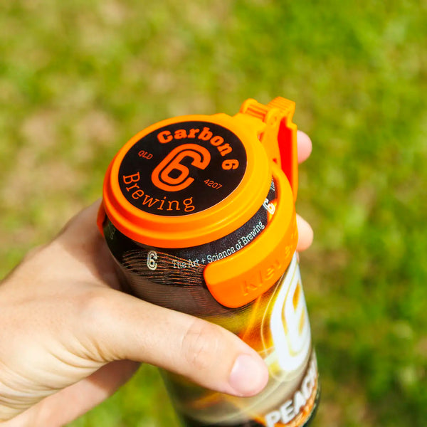 Person holding a beer can topped with a C6 Klever Cap, designed to keep debris out while enjoying a drink.