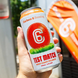 A person holding a can of The Occasional Beer with a vibrant label and condensation, perfect for enjoying in social settings.